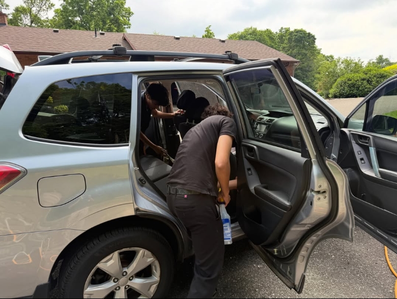 Polish & Go detailer working on a Subaru Forester interior in a Milton driveway